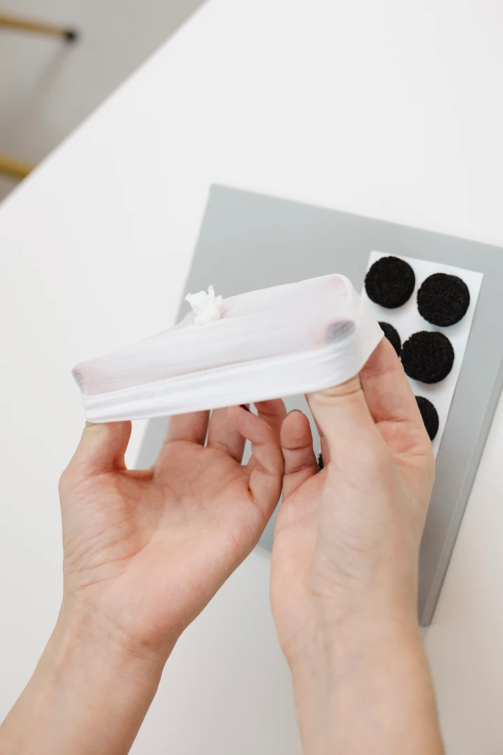 Manos de una fisioterapeuta pediátrica sujetando el gorrito para que se vea que es elástico