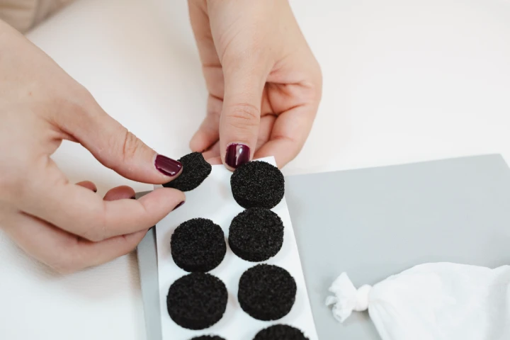 Manos de una fisioterapeuta cogiendo uno de los marcadores de su blister