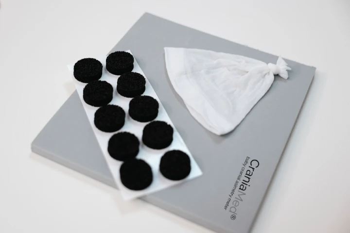 Detalle de los Materiales de medición de craniamed: esterilla gris, marcadores y gorrito